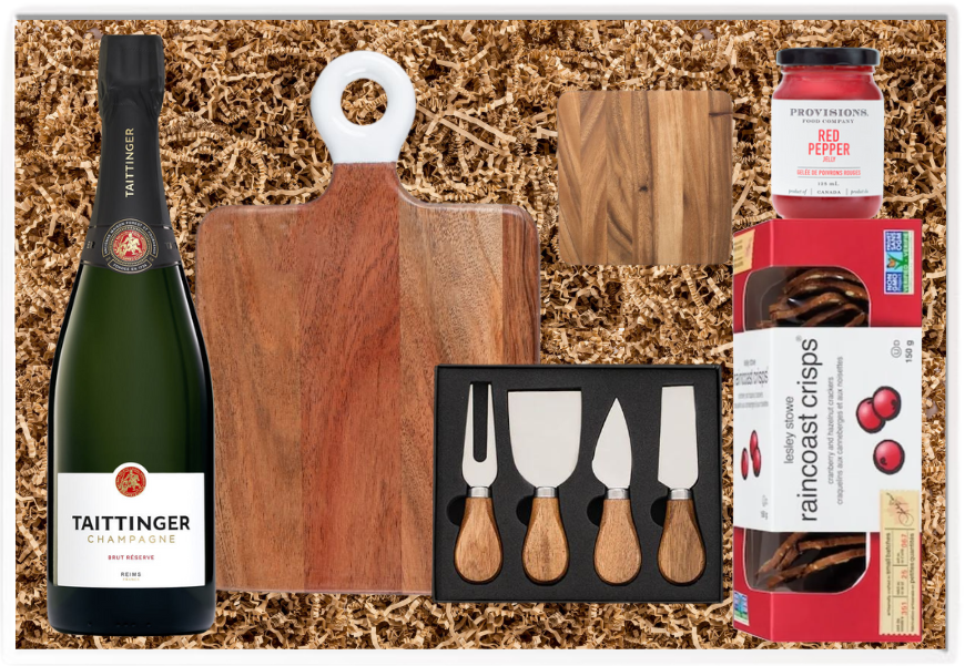 Gift set with Taittinger champagne, cheese boards, knives, and snacks on a wooden background