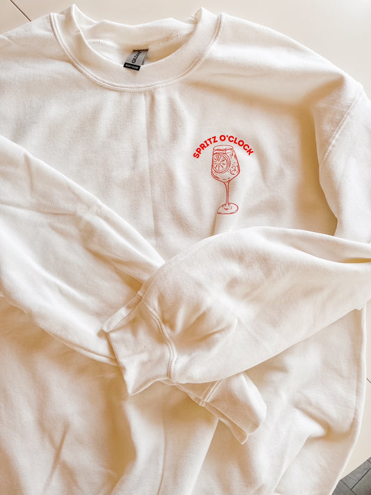 White crewneck sweater with orange logo on white background